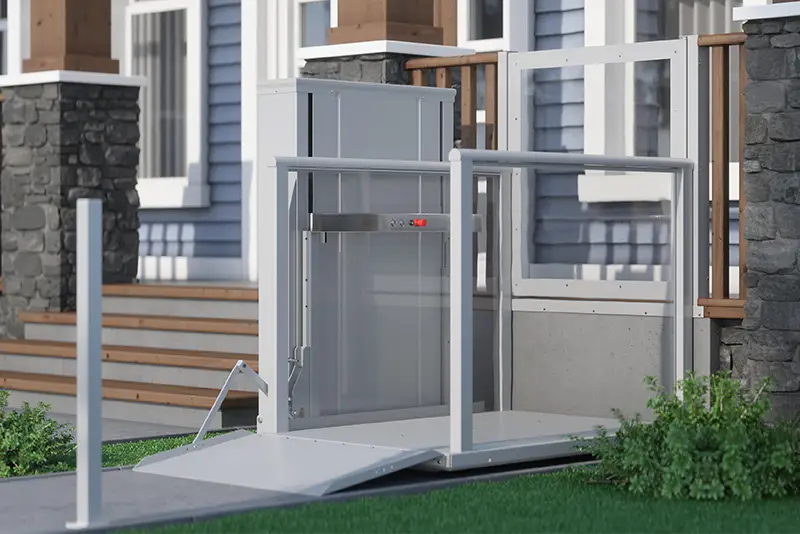 Outdoor AmeriGlide vertical platform lift next to stairs providing an accessible entry option to a home.